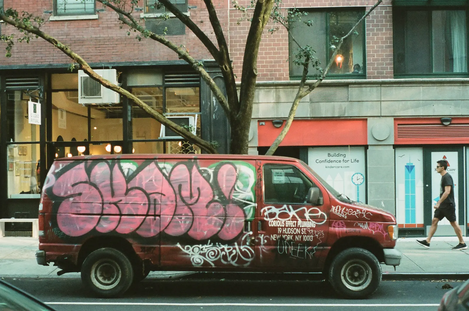 Graffiti-covered van parked on a city street