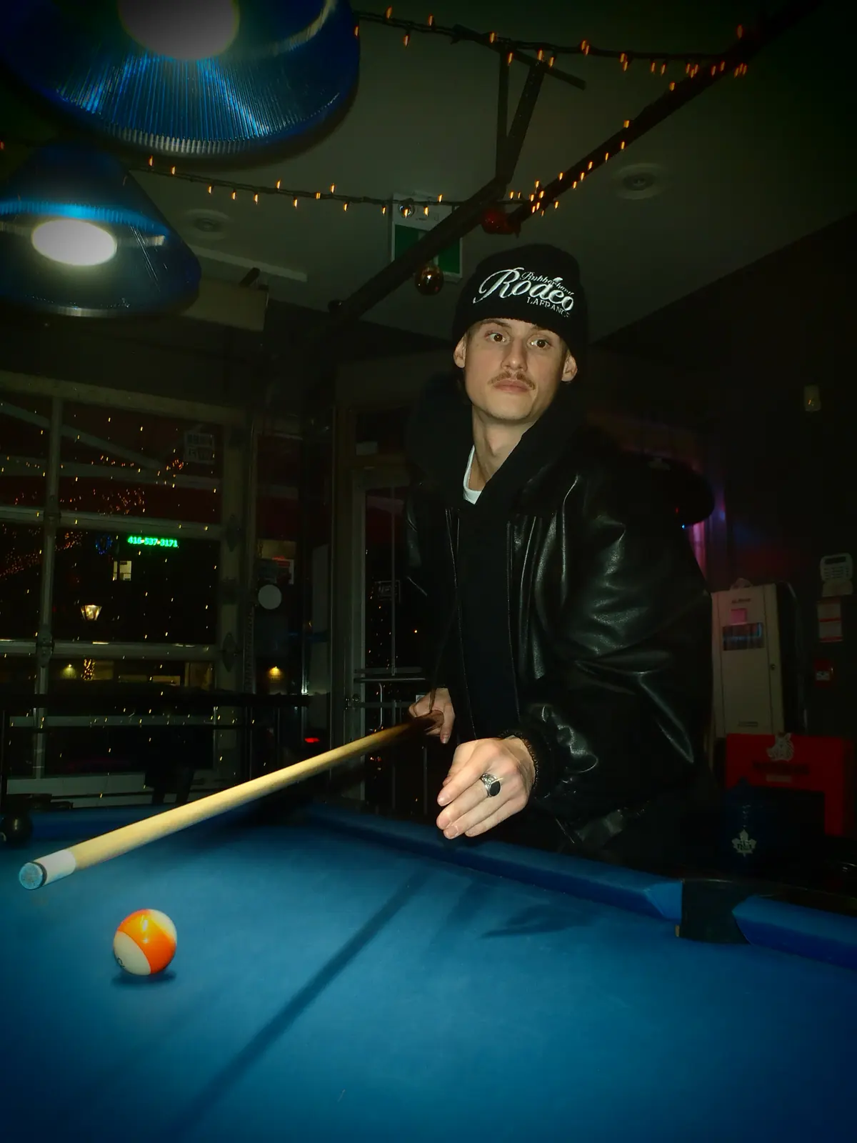 Portrait in a leather jacket at a pool table