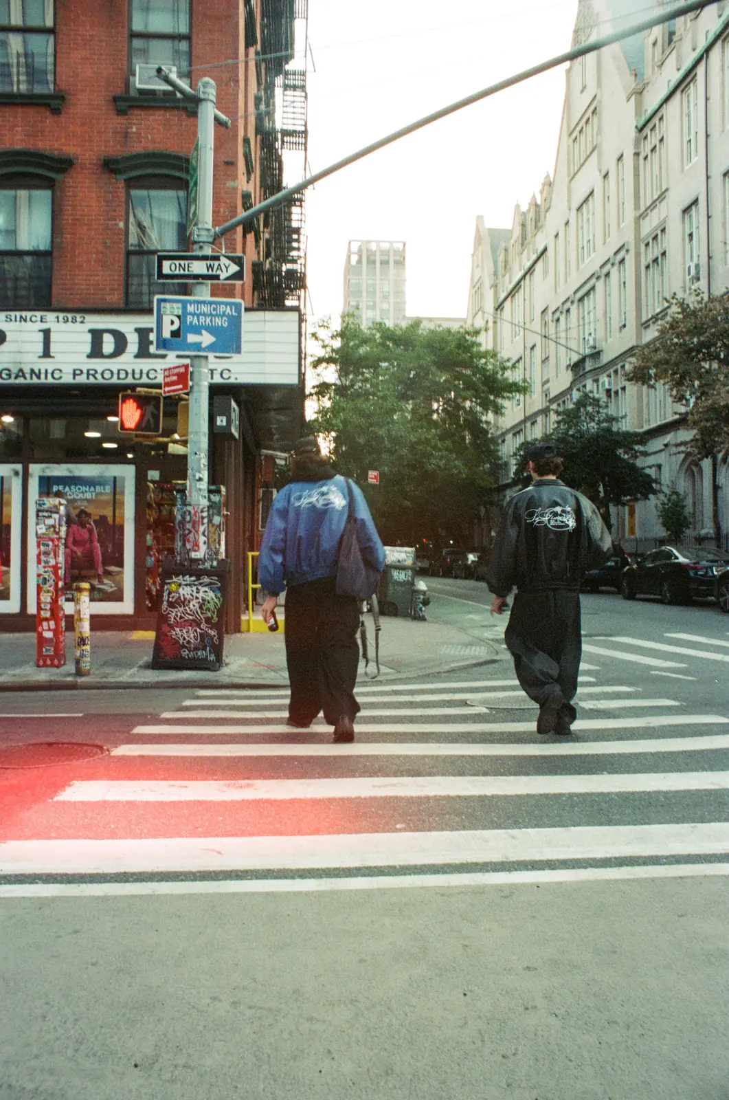 Two people walking through a city crosswalk