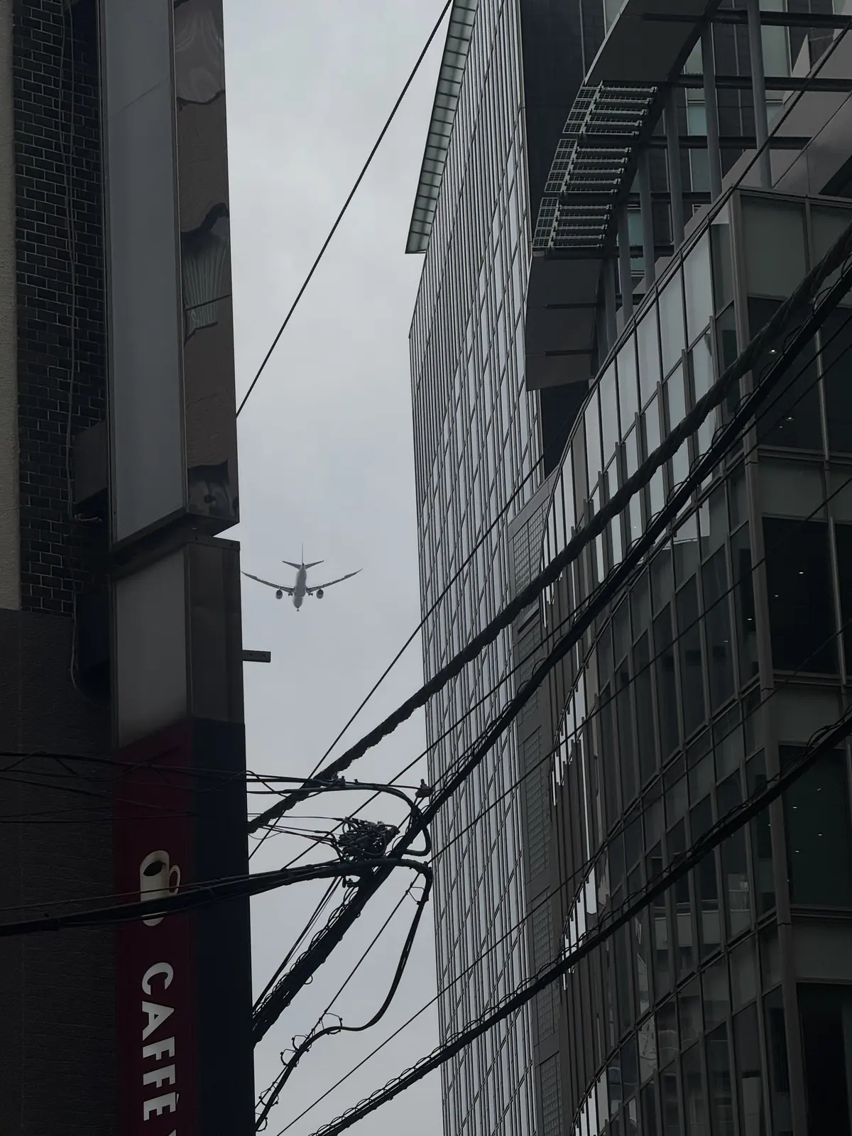 Airplane passing between tall city buildings