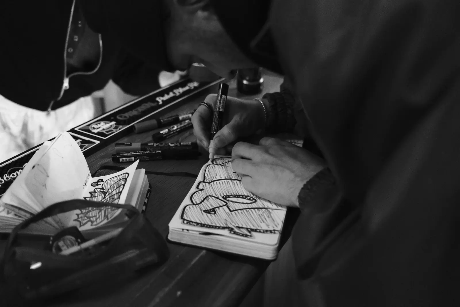 Black-and-white detail of hands working with fabric