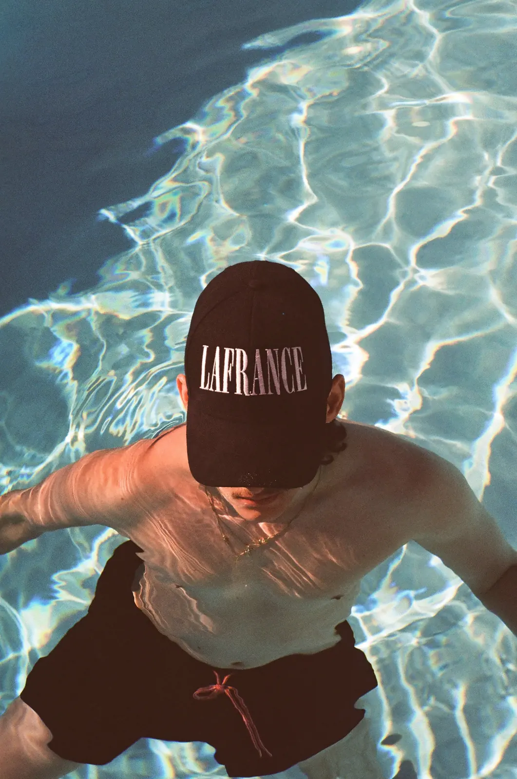 Portrait in a LaFrance cap beside a pool