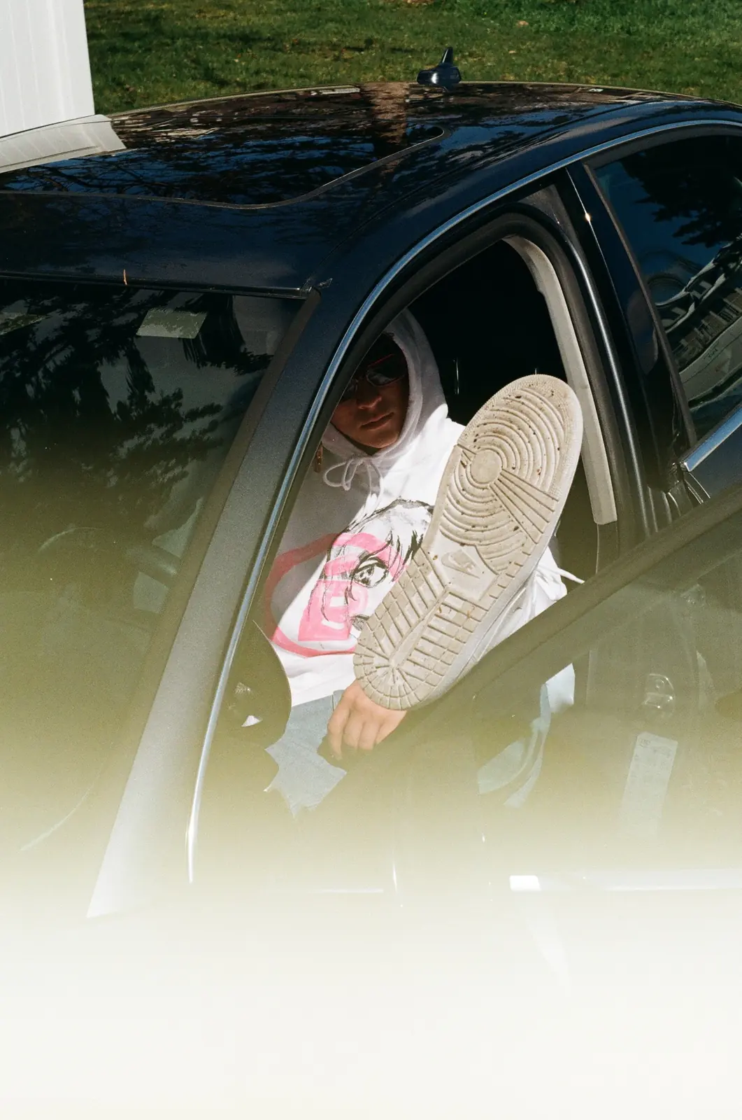 Sneaker extending from an open car window