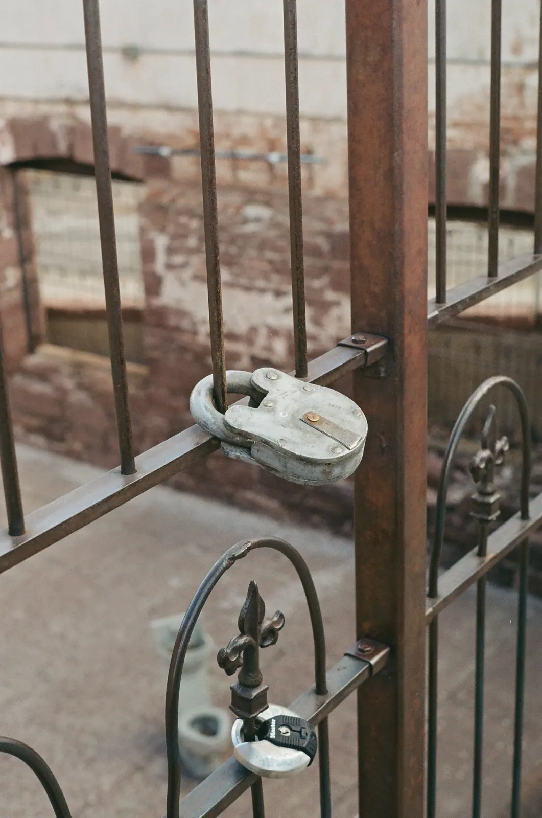 Weathered padlock attached to a metal railing
