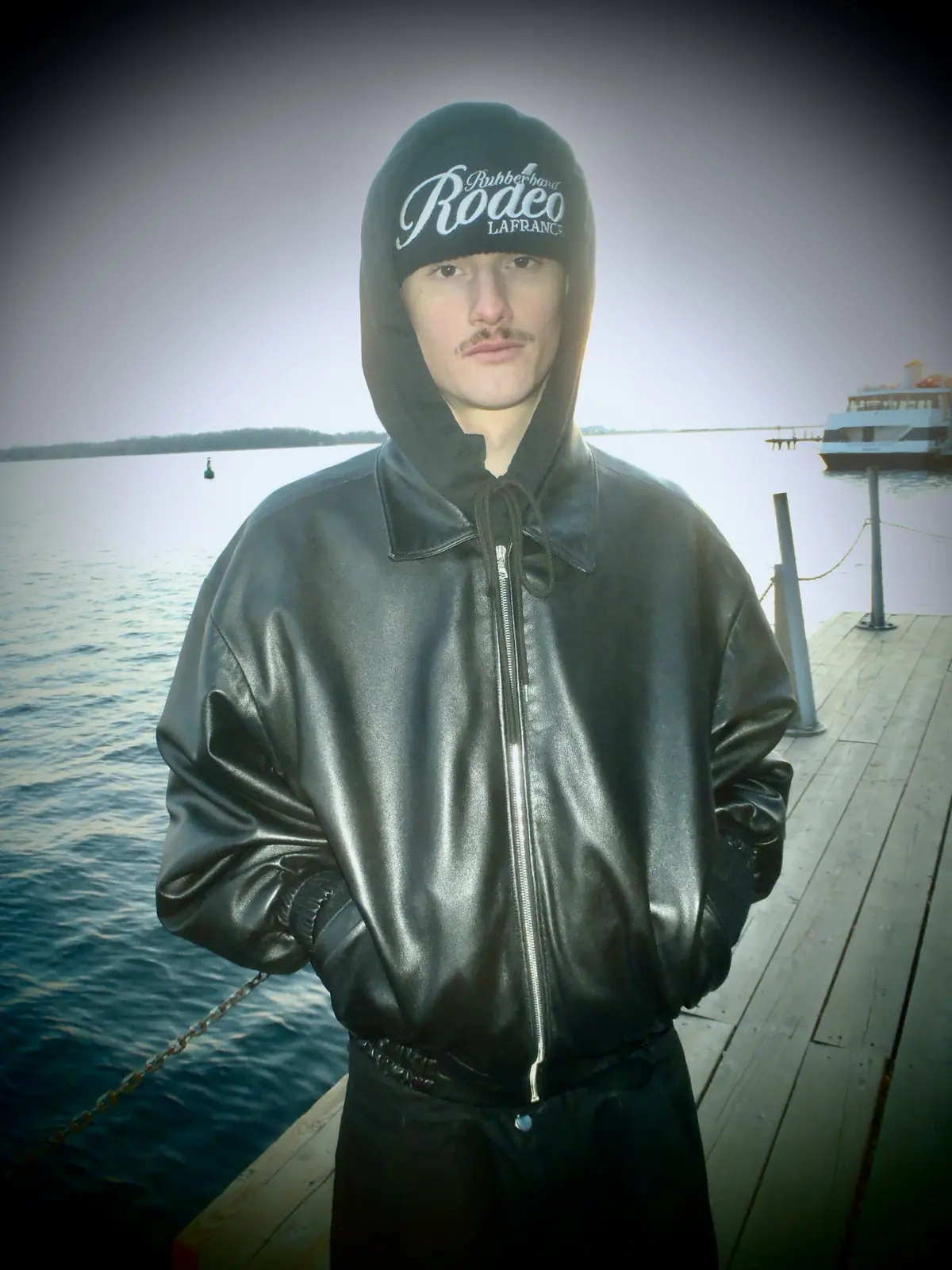 Portrait in a black leather jacket by the water